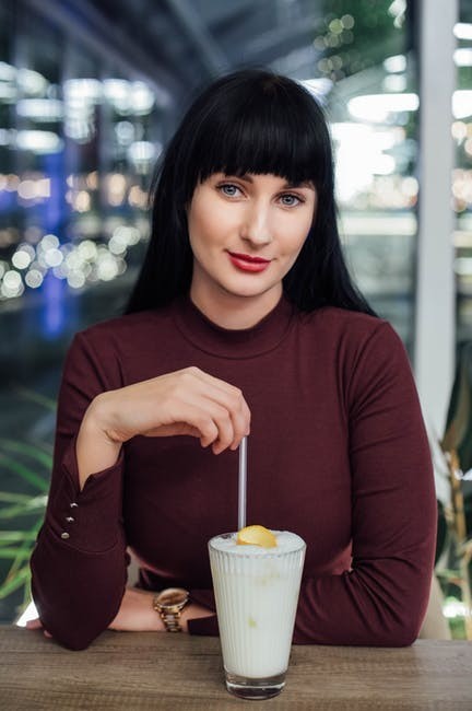 girl in maroon sweater with milkshake